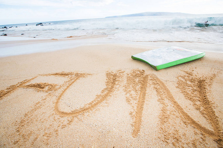 在沙滩上用沙子写的有趣这个词女性的手要在白色的背景上写字写笔记