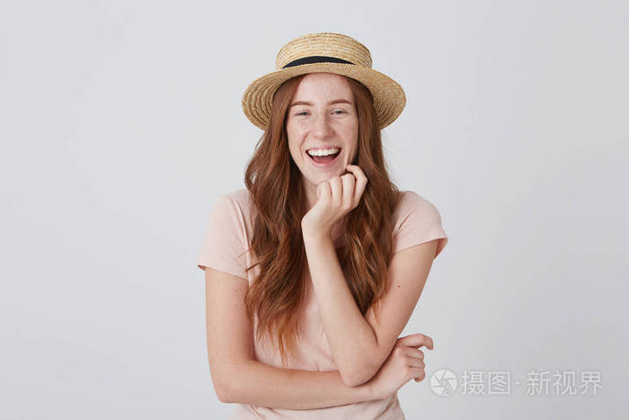 可爱的年轻姑娘,戴着草帽,留着长长的红发,用手托着下巴,在白色的背景