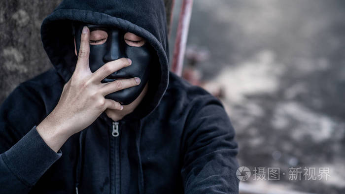 神秘人戴着黑色面具穿着帽衫闭上眼睛想着什么感到压力或头痛的手势