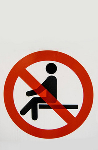 带红色圆圈的信号和一个程式化的人表示不可能坐下照片