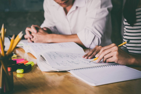 高中或大学生群体在课堂上追赶作业簿和学习辅导,阅读,做作业和备课.