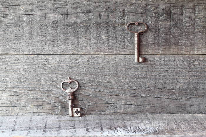旧铁键。 木制背景上的一对旧钥匙。
