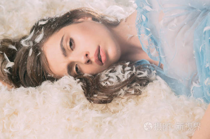 美丽的女孩淹死在柔软的床上昏昏欲睡的年轻女士睡着了休息在柔和的
