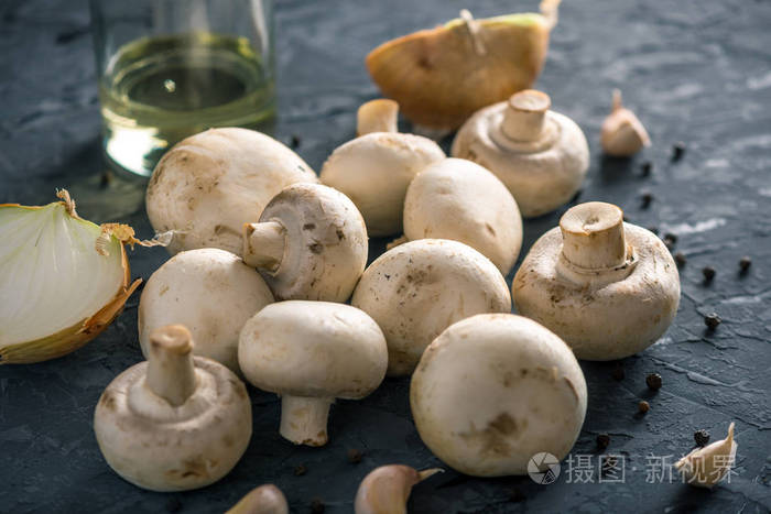 新鲜的白色冠军香料和配料在黑暗的厨房桌子上食用蘑菇菜的概念