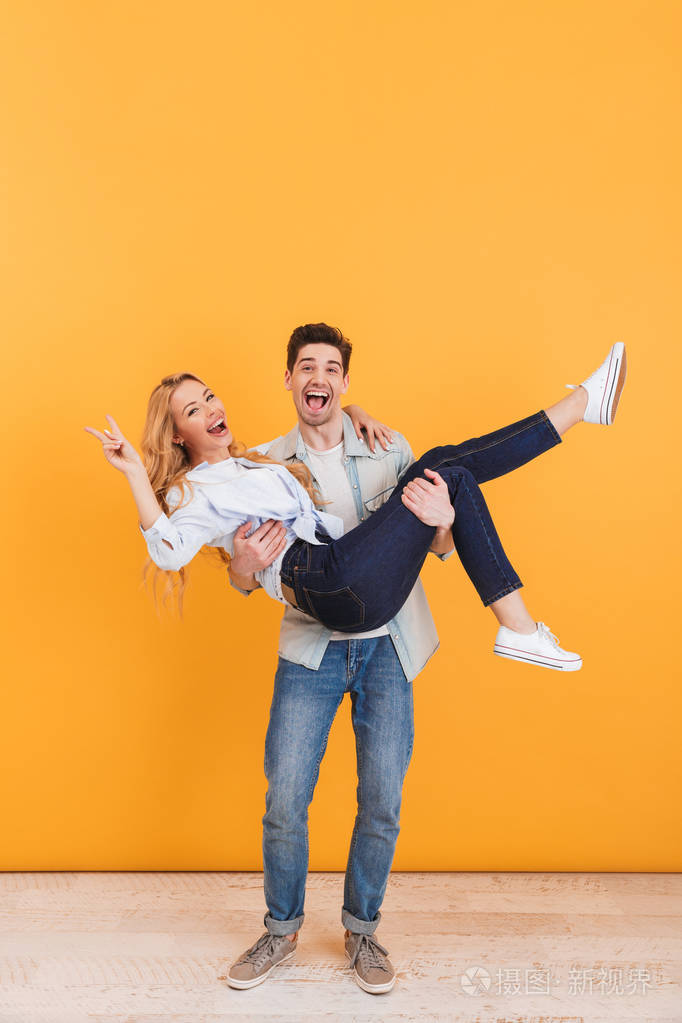 全长照片英俊的男人抱着漂亮的女人在他的怀里谁显示胜利标志孤立于