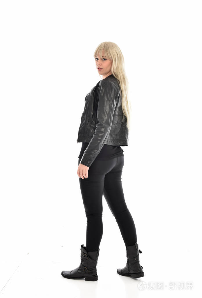 穿黑色皮衣的金发女孩的全长肖像.站姿背对着相机.