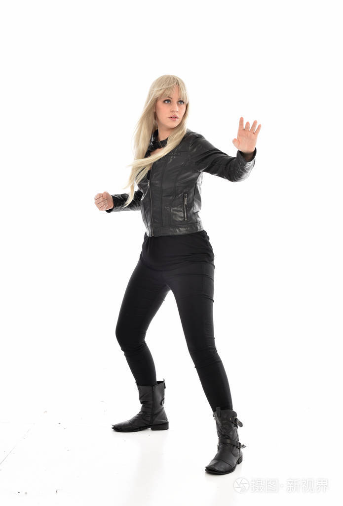 金发女孩穿黑色皮衣站姿的全长肖像孤立在白色工作室背景上