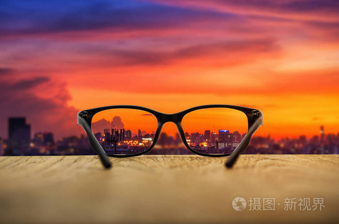 清晰的城市景观集中在眼镜镜片与模糊的城市景观背景.