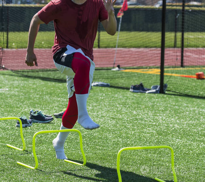 一名高中短跑运动员在脱下鞋子后的温暖的一天在田径练习中进行黄色