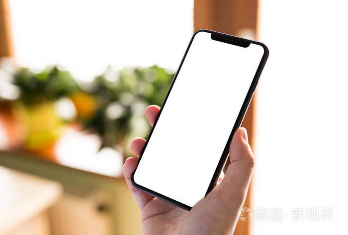 男人手拿着黑色智能手机空白屏幕和现代框架设计较少孤立在家庭内部