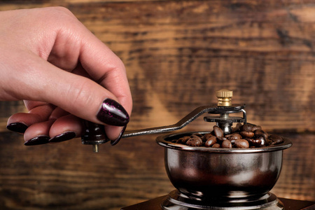 毛刺磨女人手磨烤咖啡豆在磨坊里. 复古和复古的食物和饮料概念.