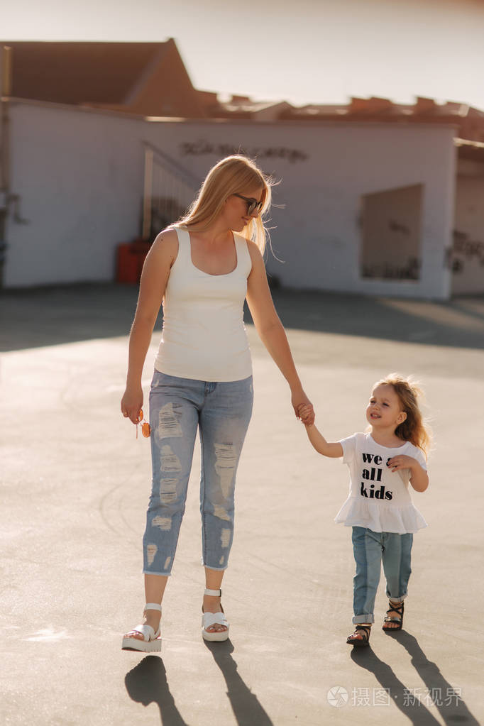 妈妈和她的女儿走着牵着手