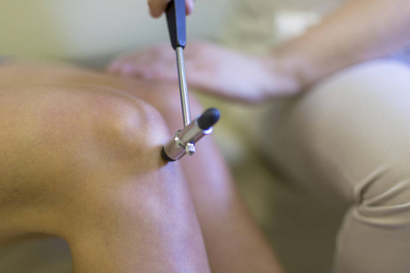 医生用神经橡胶锤对病人的膝关节反射进行神经学检查, 检查是否存在