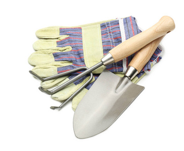 戴白色背景手套的园艺工具图片