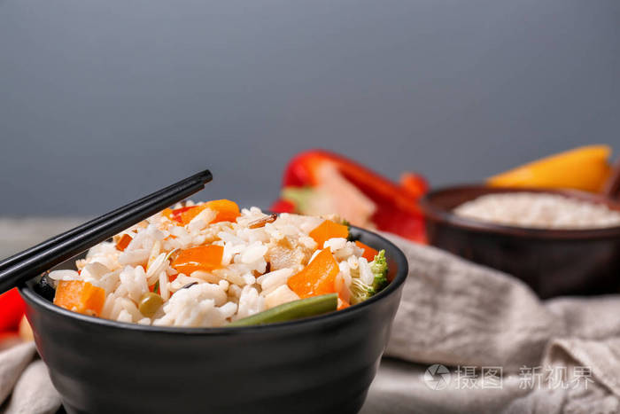 一碗美味的米饭，桌子上放着蔬菜和筷子