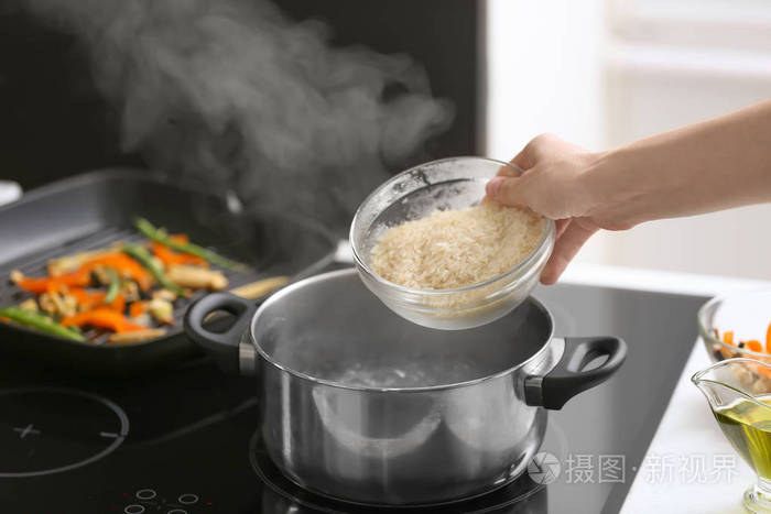 女人把饭倒进锅里烧开水