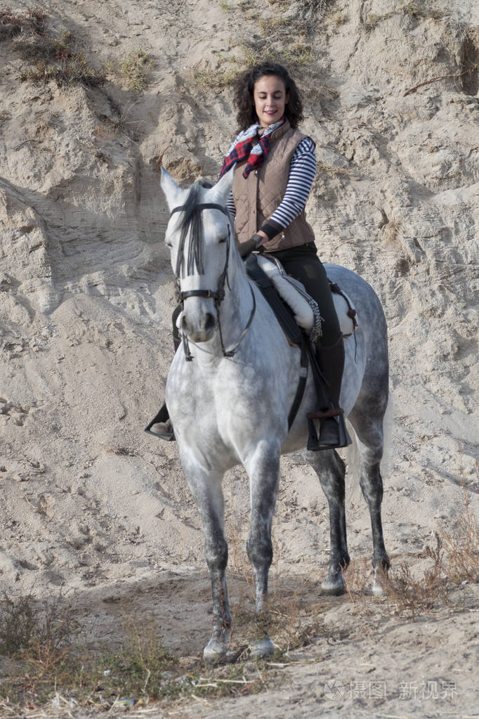 一个年轻的女人带着手帕和长发骑马