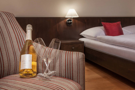 酒店房间,椅子上有一瓶葡萄酒和玻璃杯.照片
