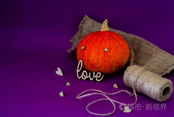万圣节的象征是橙色的南瓜使用邮票 "爱", 孤立的紫色背景, 复制空间