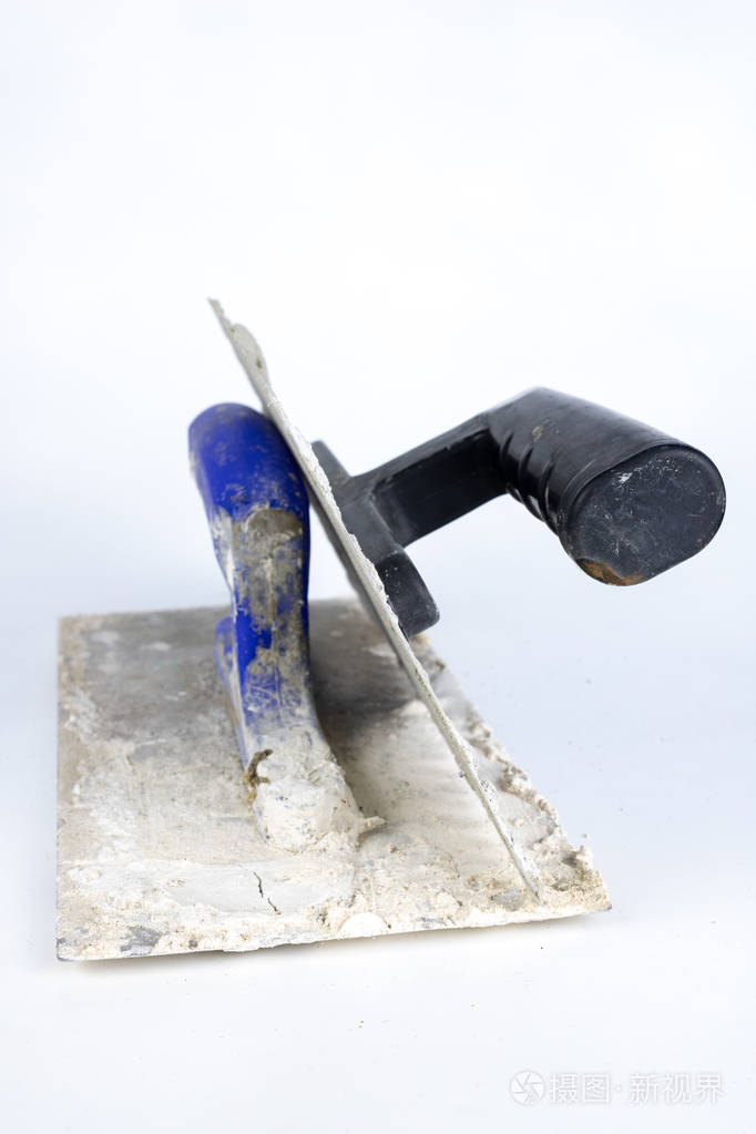 白色桌子上的肮脏的铲子石匠和建筑工人的工具白色背景