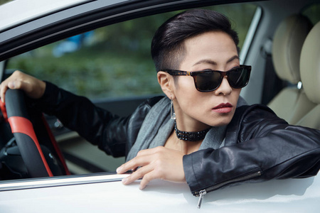 戴墨镜的女人向车窗外看的肖像照片