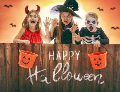 万圣嘉年华万圣节快乐的兄弟和两个姐妹.户外嘉年华服装的有趣孩子.