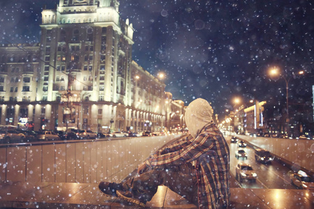 男人和夜晚城市灯光城市孤独的人概念强调道路汽车城市灯光的背景照片