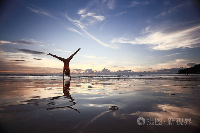 在海边做瑜伽的年轻女子
