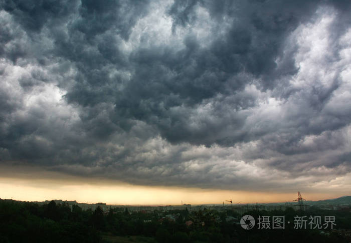 暴风雨的灰色云层在城市上空多雨的天气