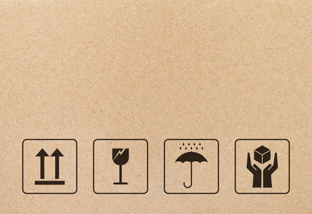 棕色纸板纸上的黑色易碎标志和符号. 脆弱的符号插图图形.照片