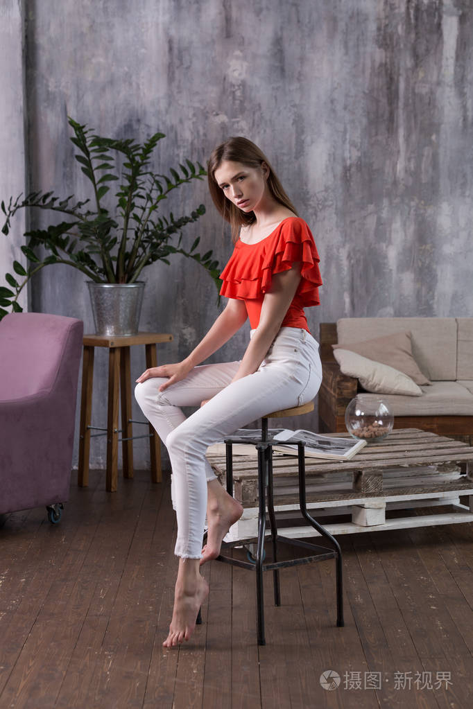 棕色头发,休闲风格,放松地坐在公寓的椅子上,在时装模特测试