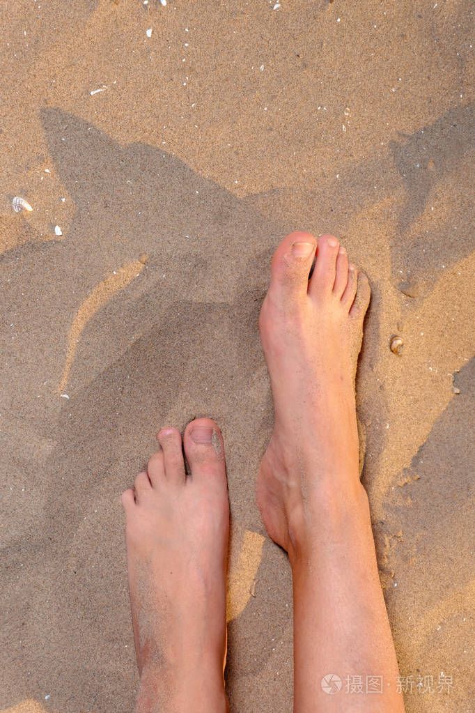 裸脚的女人在沙滩上竞争拍摄与copyspace