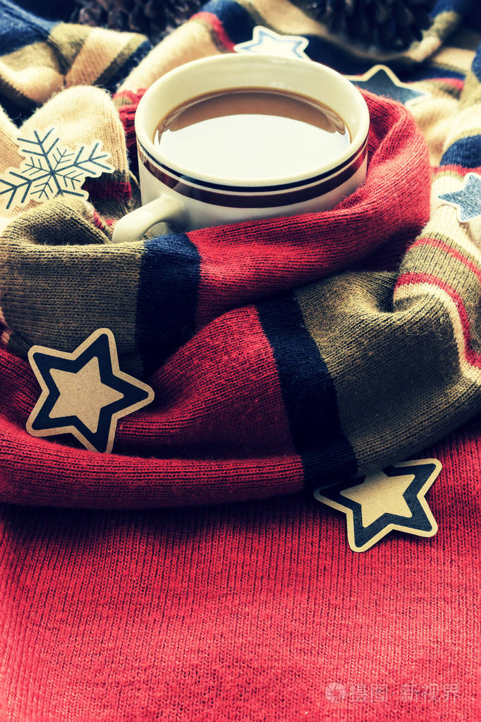 圣诞概念。 一杯带红色毛衣的咖啡。 光线照射