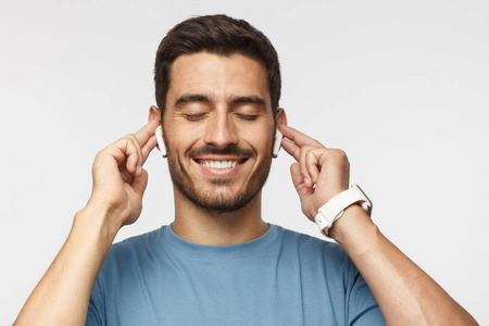 音乐氛围特写镜头身穿蓝色t恤面带微笑的年轻人在聆听自己喜爱的歌曲