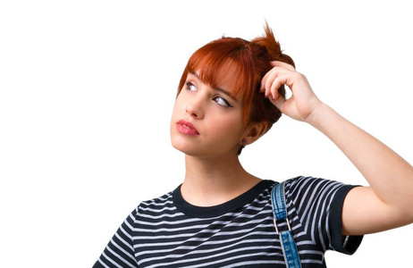 有疑问的年轻学生红头发的女孩,脸上表情混乱照片