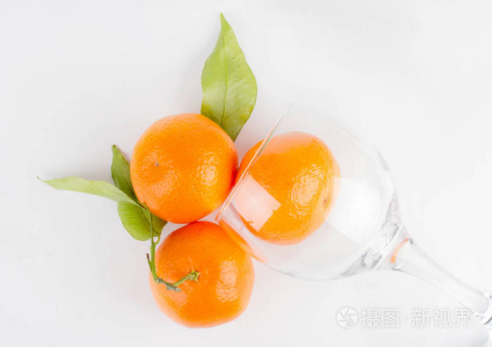 成熟的橘子和透明的果汁玻璃。 食物背景图