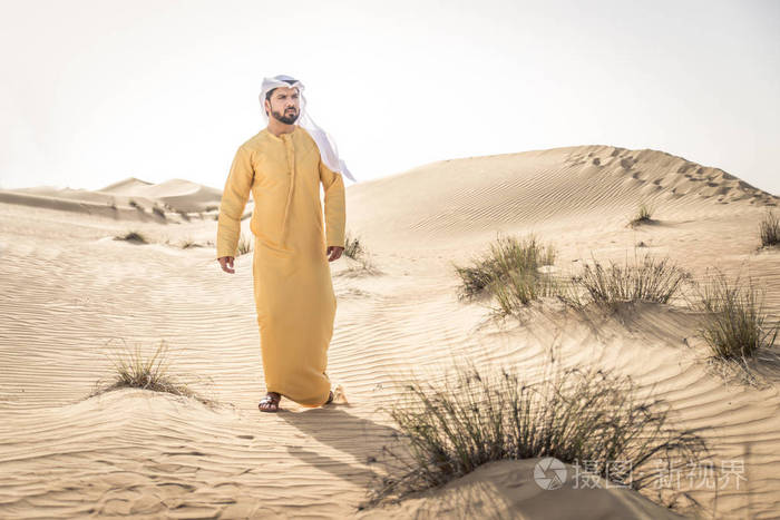 迪拜沙漠中穿着传统服装的英俊阿拉伯男人