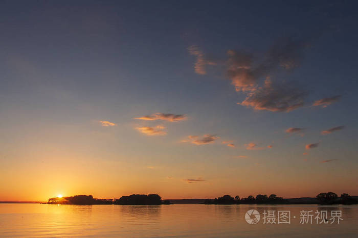 在一个美丽的湖泊地平线上的夕阳景观.黄昏时分, 湖面上乌云密布.