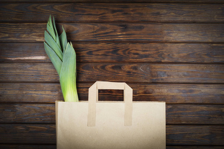 绿色产品装在纸袋里. 韭菜放在纸袋里健康食品. 超市食品配送.