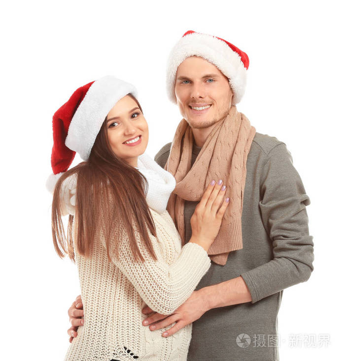 白色背景圣诞老人帽子中可爱的年轻夫妇的肖像。
