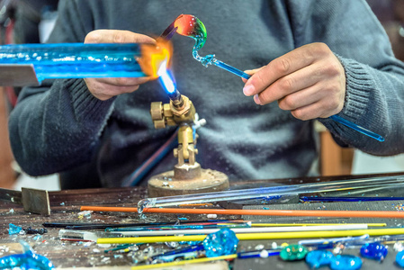 加工制作手工艺品的手在手工艺品展销会上制作玻璃制品.