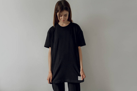 黑色潮穿着黑色t恤和牛仔裤的年轻潮人微笑女孩穿着白色背景的黑色t恤