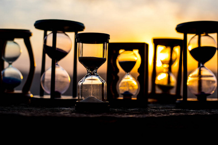 时光流逝的沙漏云. 一个沙漏在明亮的蓝天前面,白云飘过. 时间概念.