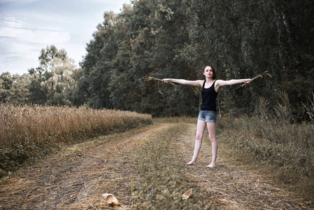 在小麦的脚年轻女孩赤脚走在地面上,穿过田野和森林,夏天和旅行的概念