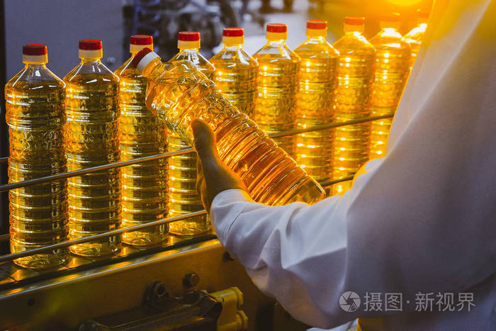 葵花籽油 橄榄油 这家工厂的员工穿着白色外套 手里拿着一瓶油在传送带上 石油生产 照片 正版商用图片1sjs6e 摄图新视界 葵花籽油 橄榄油 这家工厂的员工穿着白色外套 手里拿着一瓶油在传送带上 石油生产 照片 正版商用图片1sjs6e 摄图新视界