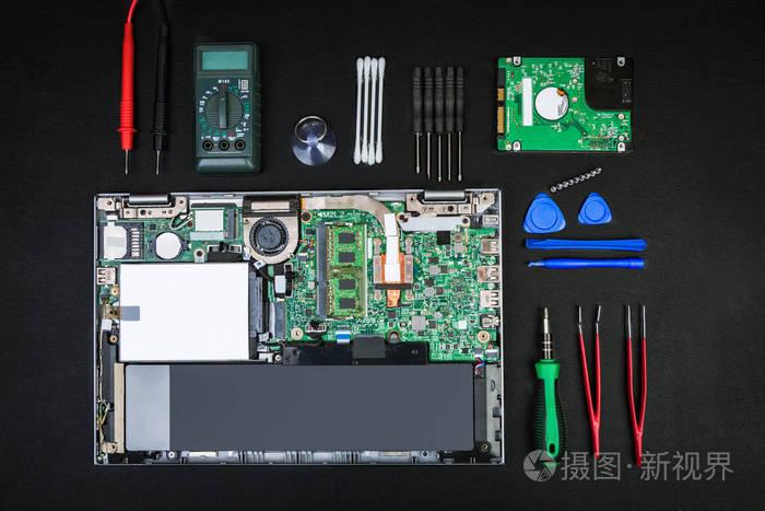 拆卸的笔记本电脑与计算机部件和特殊工具,以修理在一个黑色的桌子.