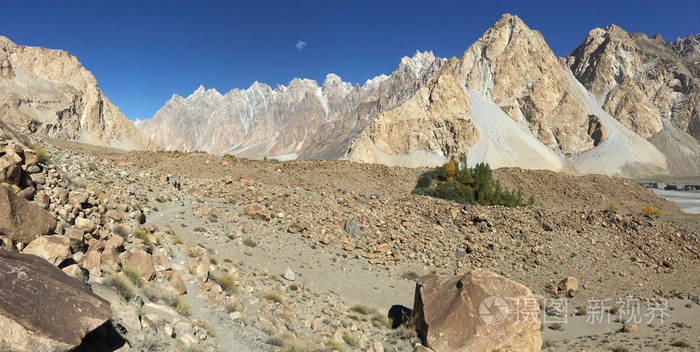 在帕苏徒步旅行的小径上展示了干旱地貌，卡拉科拉姆山脉的雪山，沿途的草和肉质植物。 巴基斯坦吉尔吉特巴蒂斯坦。