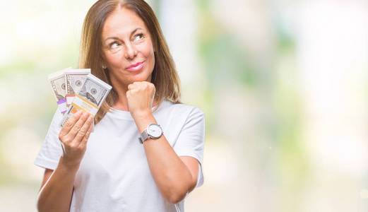 中年西班牙裔女人拿着一大笔钱在孤立的背景下严肃的面对思考问题非常