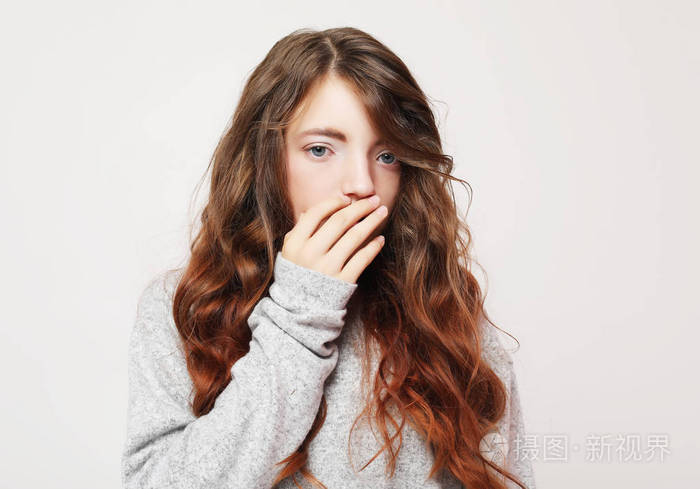 小女孩用她的手捂住她的嘴.生活方式和童年概念