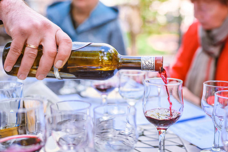 杯洒酒侍酒师把酒杯里的酒洒在露天品酒上照片